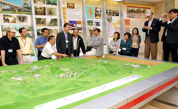 Photo 17 - Dongshen Water Supply Improvement Works Exhibition Centre - Briefing in front of a model of the dedicated aqueduct