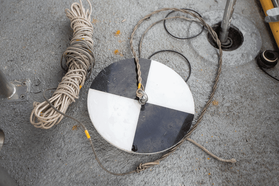 Reservoir fishermen measure the light penetration of the water body in a reservoir with a Secchi disk