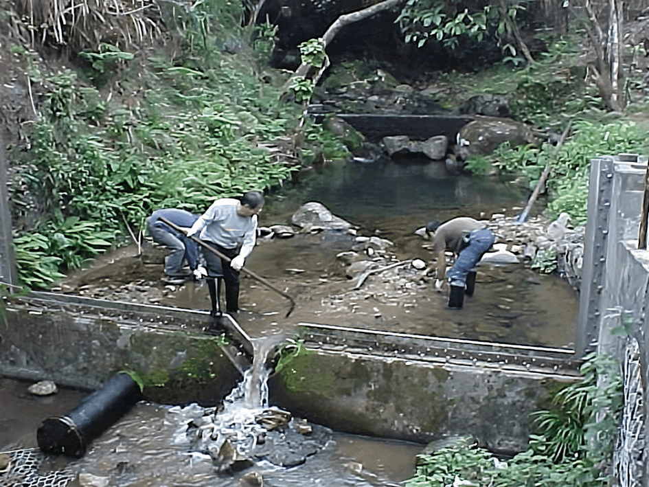 Waterworks staff clearing sediment adjacent the weir