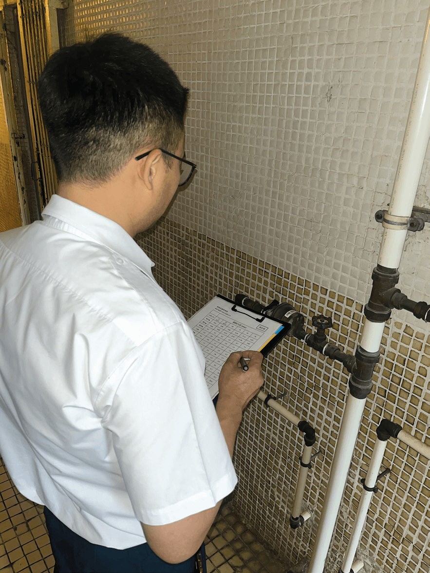A licensed plumber inspects and records whether the pipe materials and connections outside a building comply with water safety standards.