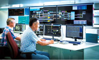 Staff monitoring operations of water treatment works through the control Photo