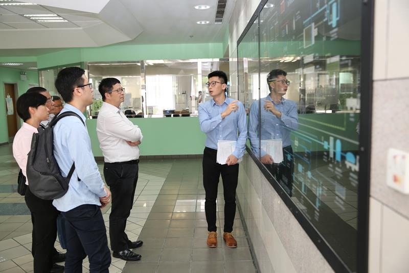 水務署職員向葵青區議會議員講解濾水過程模擬圖。