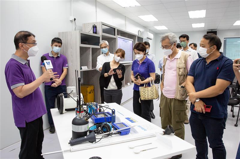 水务署职员向葵青区议会议员介绍渗漏检测技术。