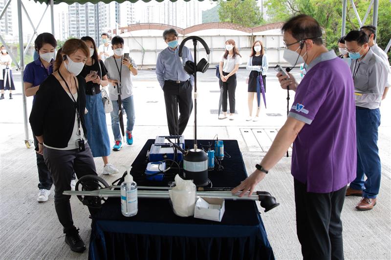 水务署职员向葵青区议会议员介绍渗漏检测仪器。