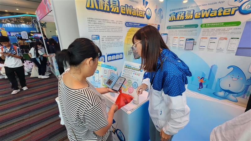 工作人員從旁協助市民下載「水務易」。